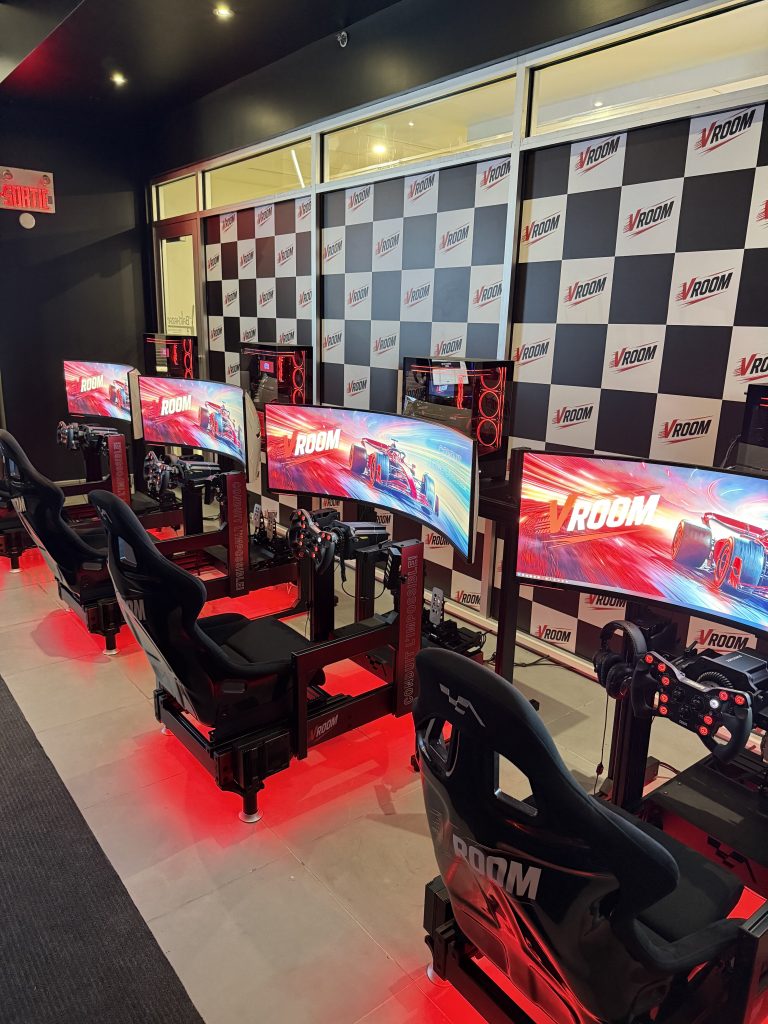 S'installation de simulateurs de course avec écrans incurvés et sièges gaming noirs équipés pour une immersion totale.